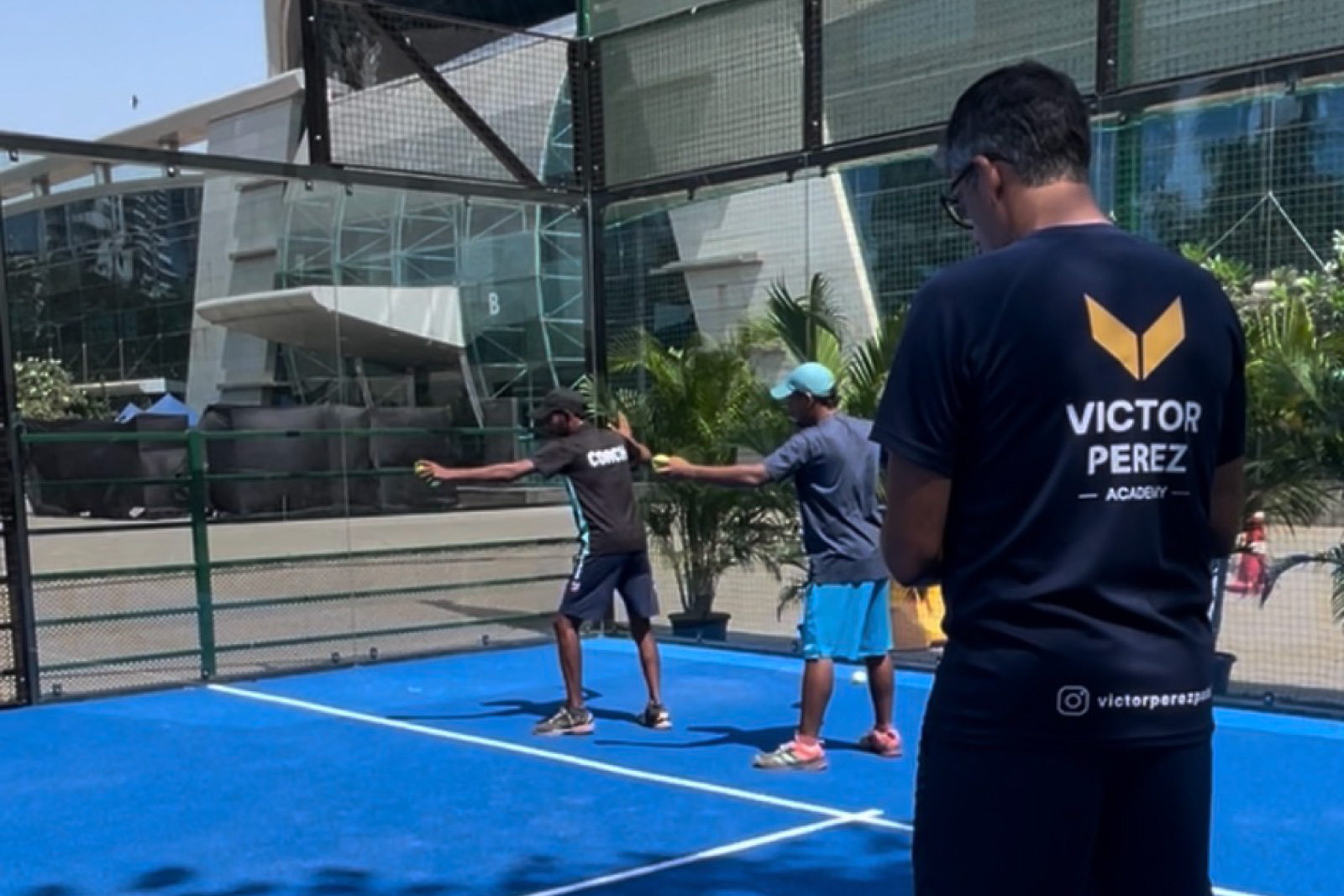 Victor Perez watching two padel coaches practise on court during the first Level 1 padel coach course in India